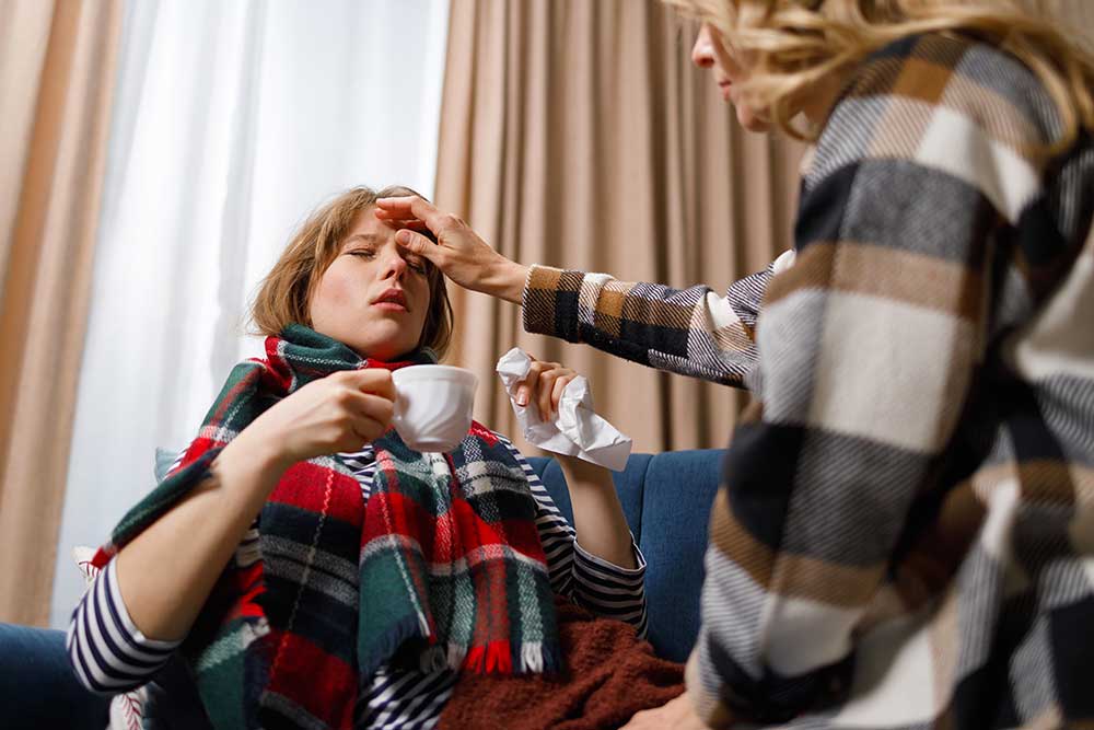 girl-with-the-flu-drinks-hot-tea-while-her-mother-2024-10-20-04-14-26-utc.jpg