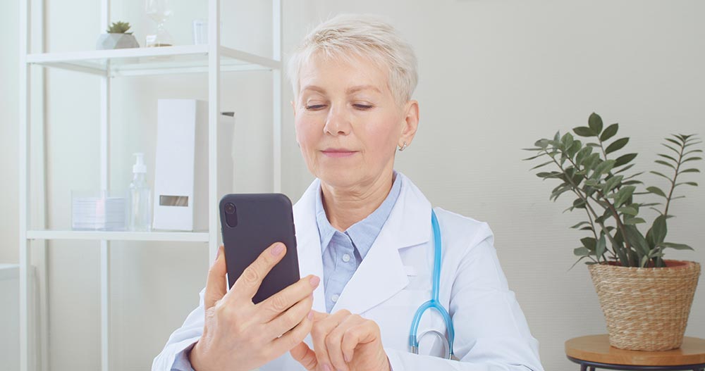 senior-doctor-using-smartphone-and-remote-teleheal-2024-10-18-07-42-24-utc.jpg