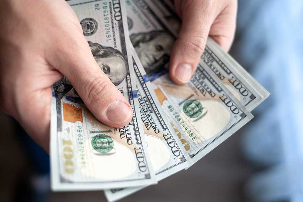 close-up-male-hand-counting-and-holding-money-us-d-2023-11-27-05-22-28-utc.jpg