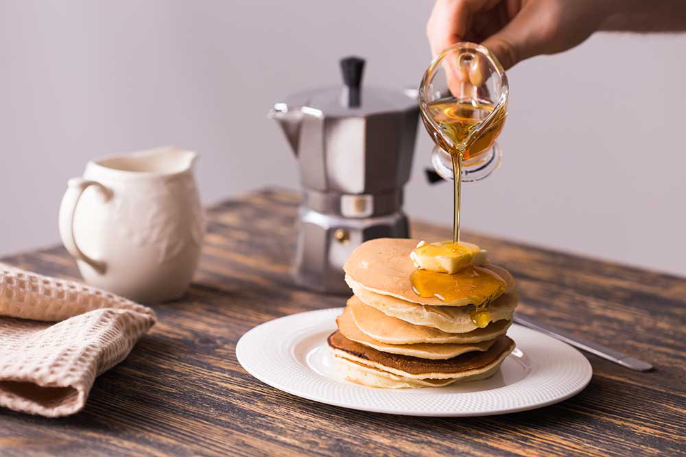 maple-syrup-pouring-over-a-stack-of-mini-pancakes-2025-02-24-18-01-53-utc.jpg