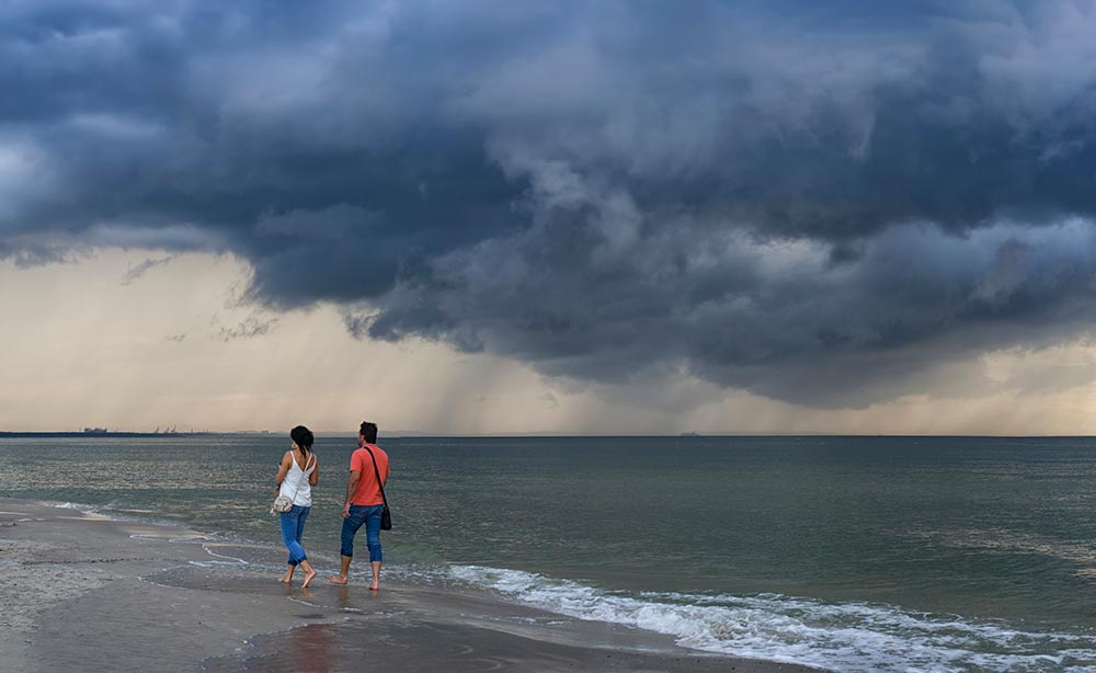 people-walking-barefoot-on-beach-under-stormy-skie-2026-01-08-07-29-12-utc.jpg