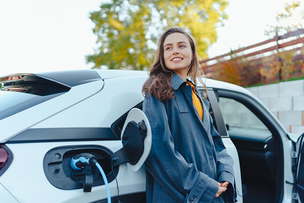 young-woman-waiting-while-her-electric-car-chargin-2026-01-05-06-12-22-utc.jpg
