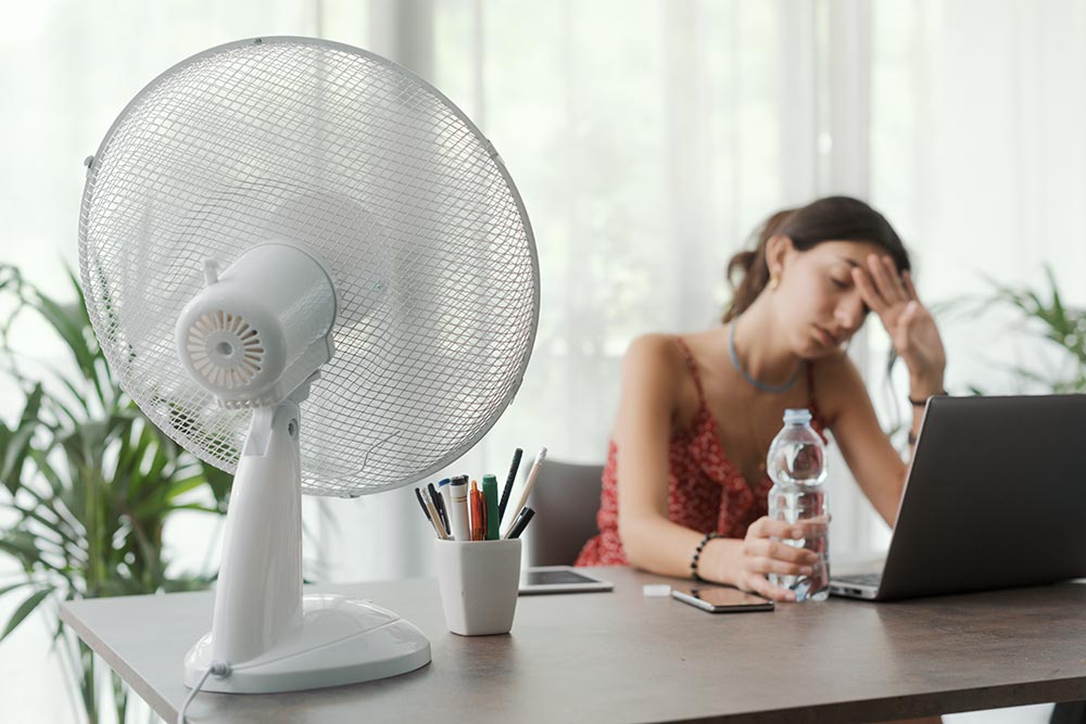 woman-cooling-herself-with-an-electric-fan-2025-01-08-10-32-49-utc.jpg