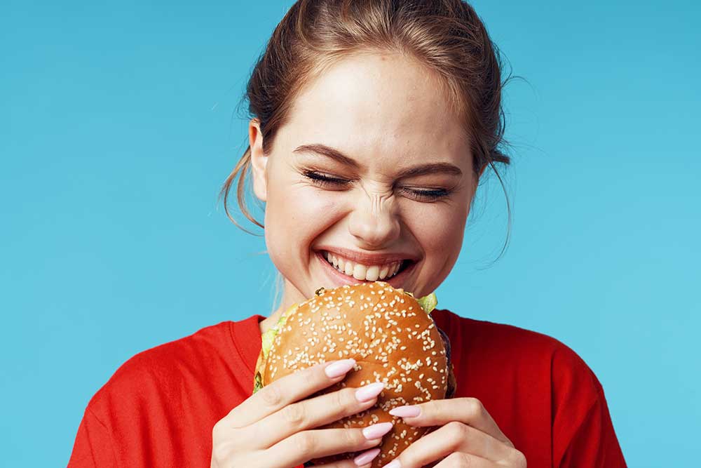 cheerful-woman-in-red-t-shirt-hamburger-in-hands-f-2025-03-10-19-18-08-utc.jpg