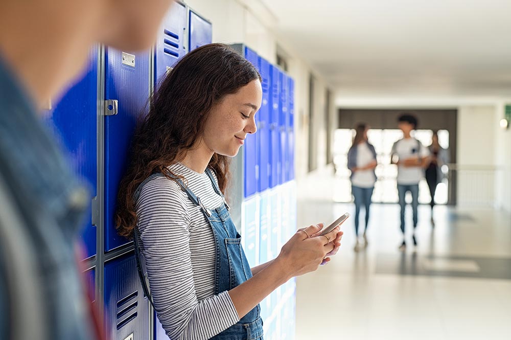 high-shool-girl-using-smartphone-near-locker-2025-01-10-04-01-49-utc.jpg