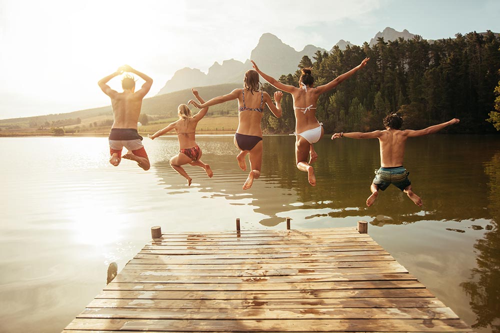 young-friends-jumping-into-lake-from-a-jetty-2024-09-18-20-31-03-utc.jpg