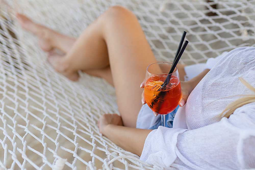 woman-with-cocktail-relaxed-in-hammock-2025-03-06-04-18-51-utc.jpg
