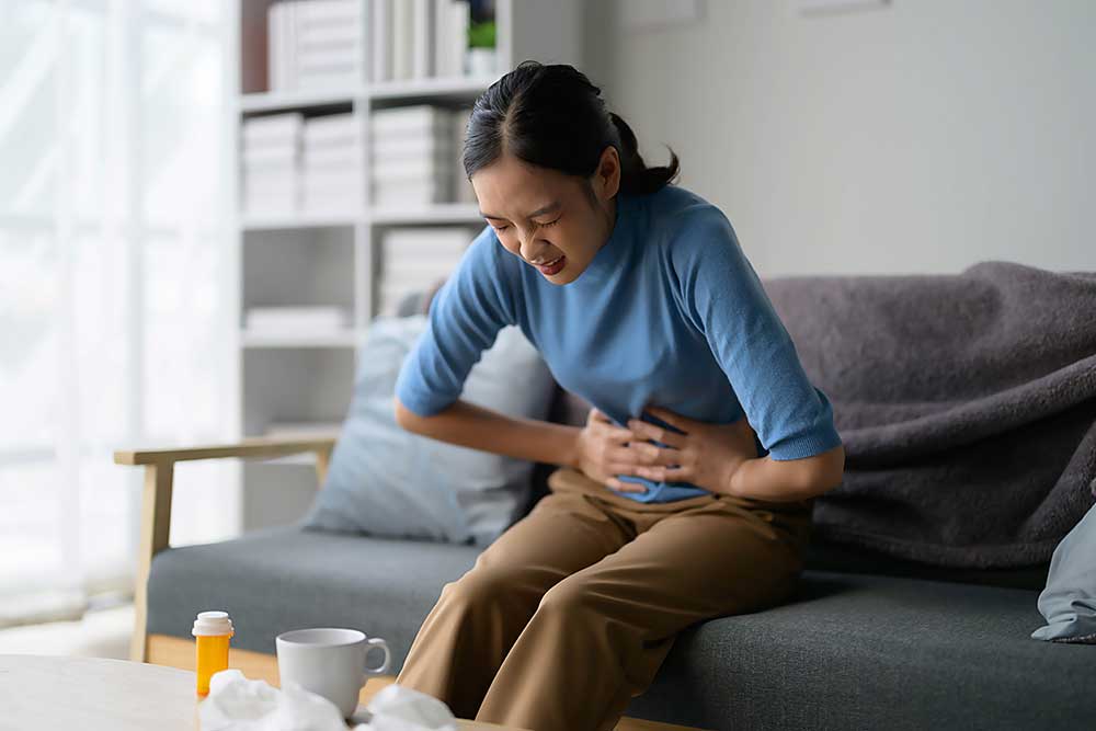 woman-experiencing-stomach-pain-while-sitting-on-s-2025-01-10-13-33-29-utc.jpg