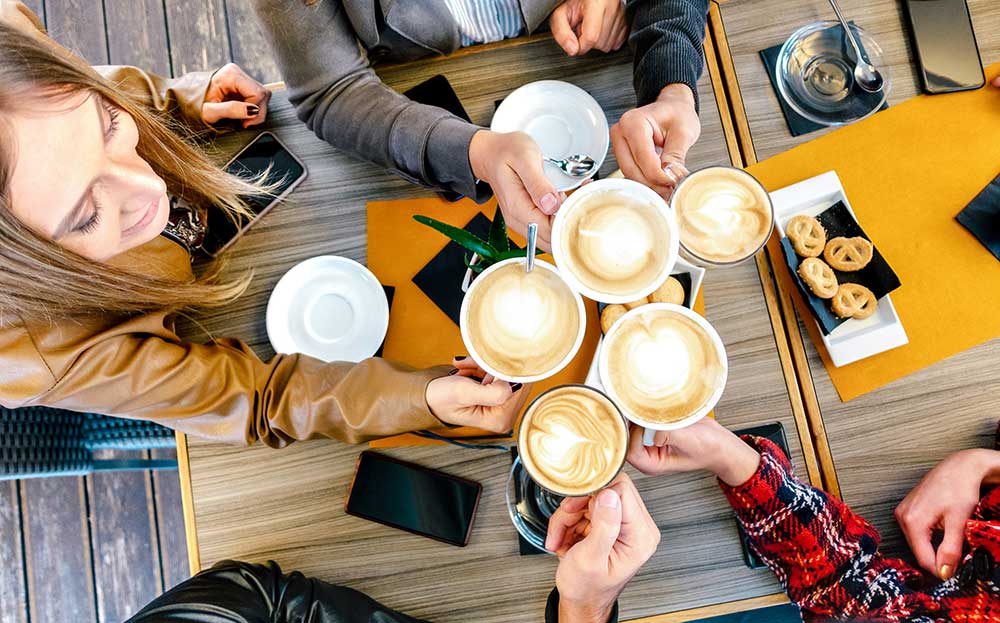top-view-of-friends-toasting-cappuccino-at-coffee-2024-07-03-02-44-10-utc.jpg