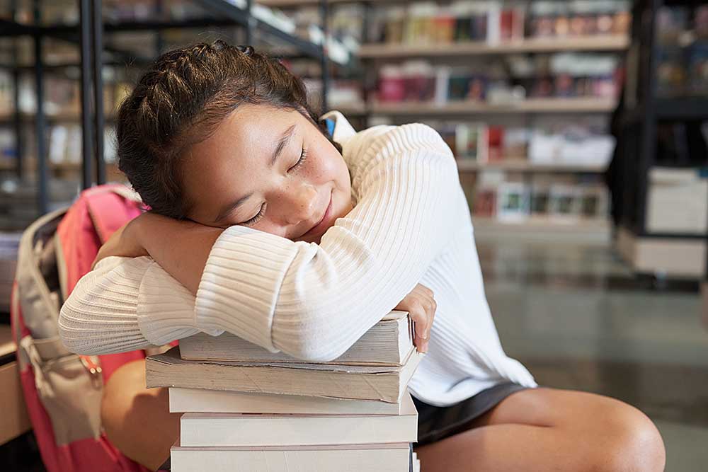 school-girl-lying-on-pile-of-textbooks-2025-01-29-07-52-34-utc.jpg