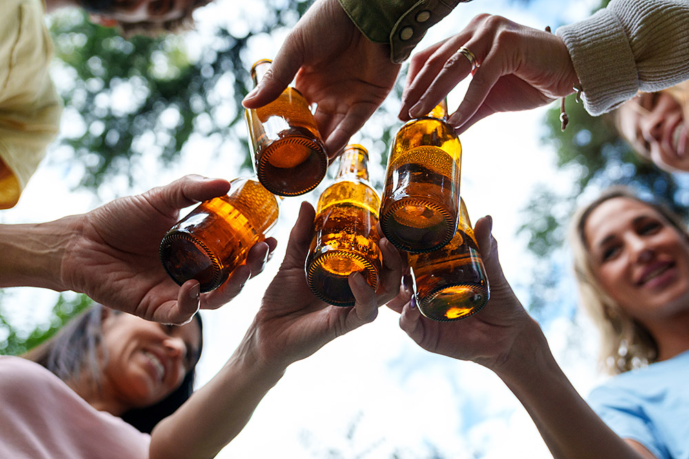 friends-toasting-with-bottles-of-beer-outdoors-in-2025-03-09-19-14-38-utc.jpg