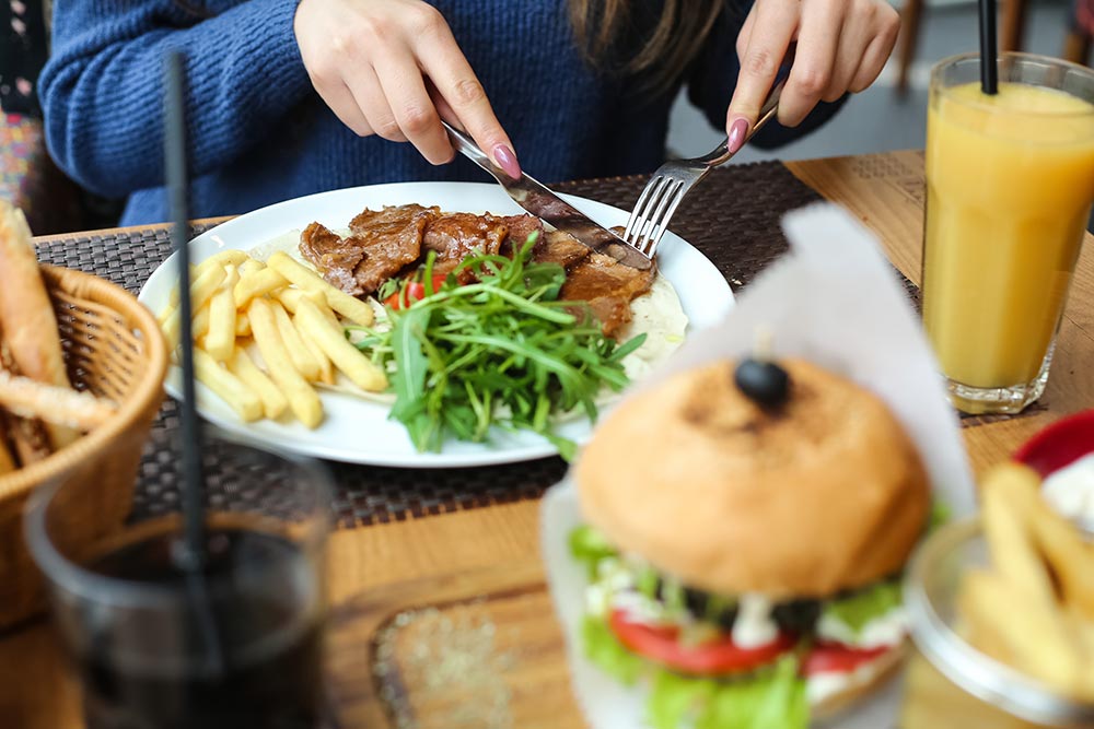 front-view-woman-eating-grilled-meat-with-fries-an-2024-10-14-11-40-43-utc.jpg