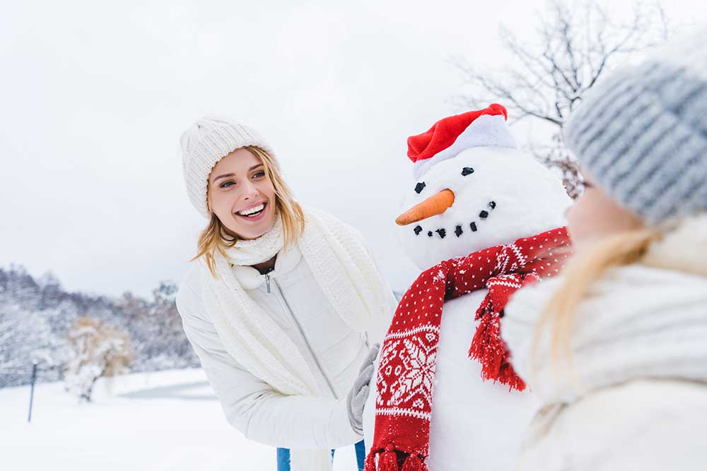 happy-mother-and-daughter-standing-near-snowman-to-2024-11-18-20-28-10-utc.jpg